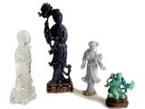quatre figurines de formes et de tailles différentes posées sur une surface blanche