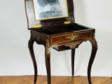 an old wooden desk with a mirror on top of it on a hard wood floor