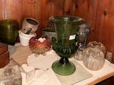 a green glass vase sitting on top of a wooden table