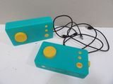 deux manettes Nintendo Wii bleues et jaunes posées sur une table blanche