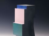 black, pink, blue, and green block sculpture on a white surface