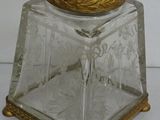 a glass jar with a gold lid on a white surface