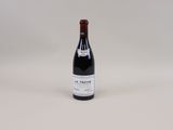 une bouteille de vin rouge posée sur une table blanche