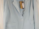 light blue blazer jacket on a hanger on a bed