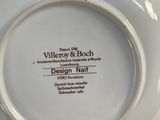 a white plate with a design on it in a person ' s hand