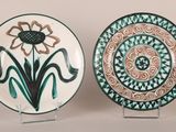 deux assiettes décoratives ornées de motifs, posées sur une table