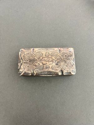 an antique silver money clip with a floral design on it