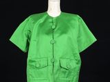 a green jacket on a mannequin stand against a black background