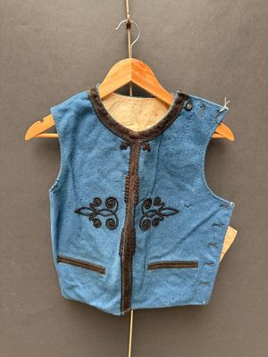 un gilet bleu accroché à un cintre au mur