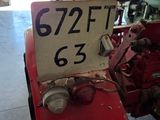 a red tractor with a number on it in a garage