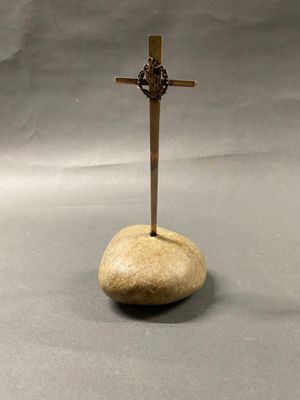 ANONYME Crucifix en argent reposant sur un galet.