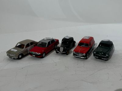 several toy cars are lined up in a row on a white surface