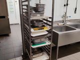 a kitchen with a sink and a rack with pans on it