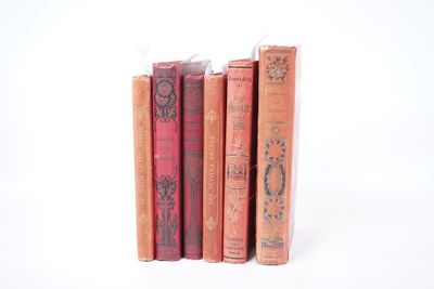 plusieurs vieux livres sont empilés sur une surface blanche