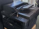 a black printer sitting on top of a wooden shelf