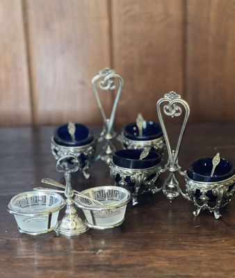 un ensemble de plats en verre argenté et bleu posés sur une table en bois