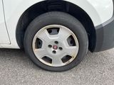 a small white car with a flat tire on the street