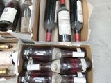 several bottles of wine are in a cardboard box on the floor