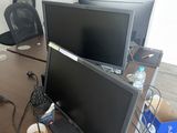 a desk with two monitors and a keyboard on it