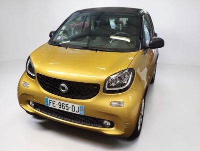 La Smart est garée sur le sol blanc de la pièce.