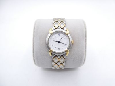 wrist watch with two tone gold accents on a white display case