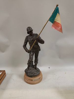 figurine d'un soldat tenant un drapeau sur une base en bois