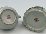 three pieces of chinese pottery sitting on top of a white surface