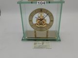 a small glass case with a clock inside of it