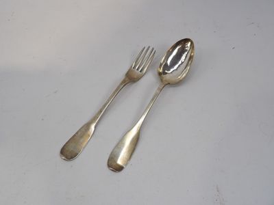 deux cuillères et une fourchette en argent sur une table