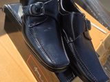 une paire de chaussures pour homme dans une boîte posée sur un carton