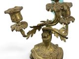 a brass candle holder with a bird on top of it