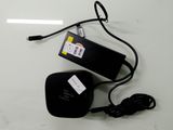 un bloc d'alimentation noir et un chargeur posés sur une table blanche