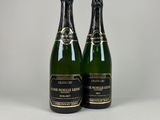 deux bouteilles de champagne posées l'une à côté de l'autre sur une table