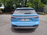 the rear end of a blue suv parked in a parking lot