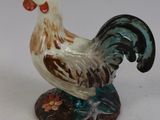 une figurine représentant un coq sur fond blanc