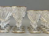six crystal goblets with gold rims on a table