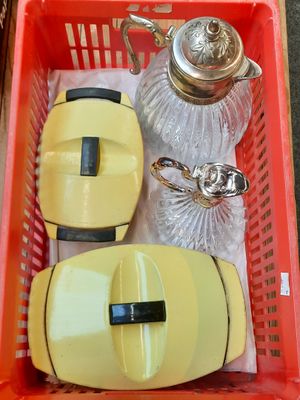 un panier rouge contenant une théière, une bouilloire et d'autres objets