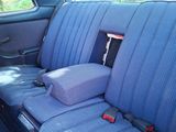 a seat in the back of a car with a pillow on it