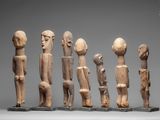 several carved wooden figures are standing in a row
