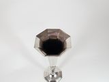 an image of a silver vase with a black lid on a white surface