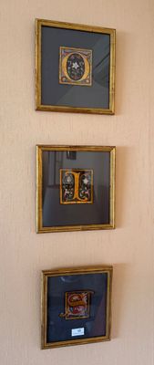trois tableaux encadrés accrochés au mur d'une pièce