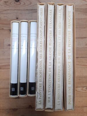 Plusieurs livres sont empilés les uns sur les autres sur une table en bois.