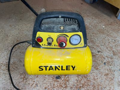 a yellow and black air compressor sitting on the floor