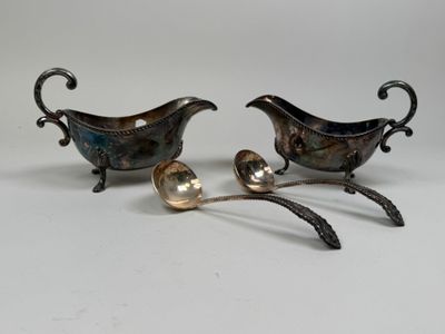 deux assiettes et cuillères en métal argenté posées sur un fond blanc