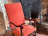 a red chair sitting in front of a fire place