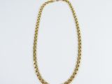 a gold chain necklace on a white background