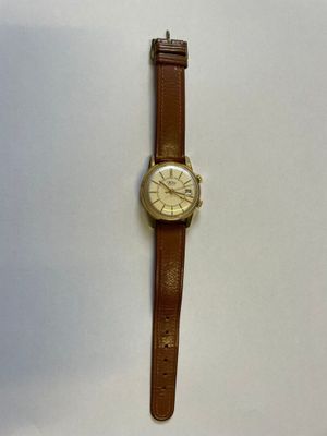 un gros plan d'une montre sur une surface blanche avec un fond blanc