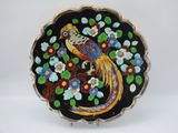 une photo d'une assiette décorative sur laquelle figure un oiseau