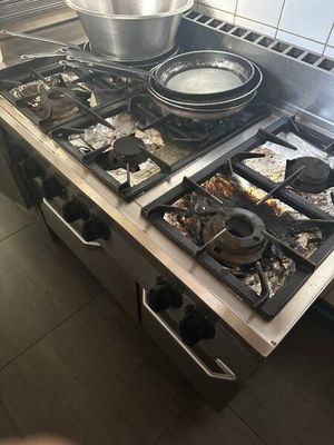 une cuisinière sur laquelle est posée une marmite dans une cuisine