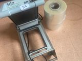 a machine that is sitting on the floor next to a roll of toilet paper
